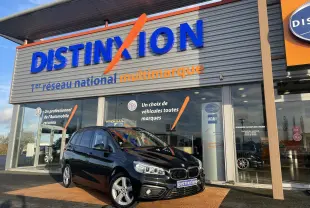 BMW Série 2 Gran Tourer noire vue en 3/4 avant droit devant un showroom Distinxion multimarque.