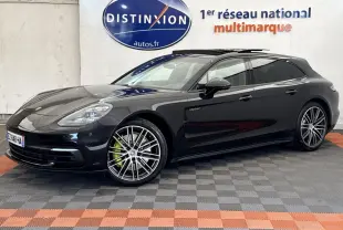 Vue 3/4 avant droite d'une Porsche Panamera 4 E-Hybrid Sport Turismo noire avec jantes alliage et logo "e-hybrid" sur la porte.