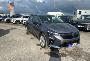 Renault Clio 2025 gris schiste vue 3/4 avant avec phares LED et calandre noire sur parking extérieur.