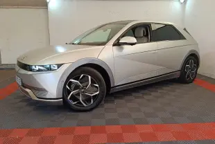 Hyundai IONIQ électrique beige vue 3/4 avant droit dans un garage avec jantes noires et grises distinctives.