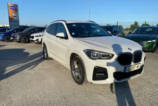 BMW X1 Mineralweiss Métalisé vue 3/4 avant droit avec calandre noire et jantes alliage en extérieur.