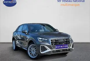 Audi Q2 35 TDI S line gris Daytona nacré en 3/4 avant, mettant en valeur sa calandre distinctive et ses jantes alliage.