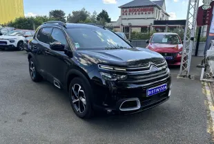 Citroën C5 Aircross noir métallisé en 3/4 avant droit, avec calandre distinctive et jantes bicolores visibles.