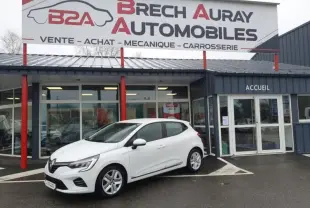 Renault Clio blanc vue 3/4 avant droit stationnée devant un garage Brech Auray Automobiles.