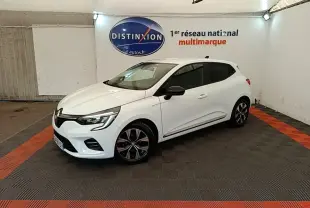 Renault Clio blanche vue 3/4 avant droit, avec jantes noires et rétroviseurs noirs dans un showroom.