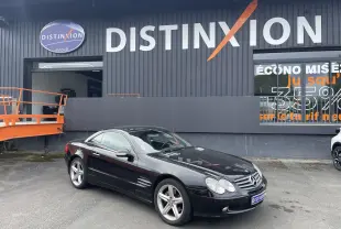 Mercedes Classe SL 500 noire vue en 3/4 avant droit, avec jantes alliage et calandre chromée devant un bâtiment Distinxion.