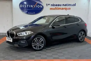 BMW Série 1 116d Business Design noire vue de profil droit en intérieur avec jantes alliage et phares LED allumés.