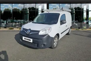 Renault Kangoo blanc vue 3/4 avant droit avec galerie de toit et pare-chocs noir mat sur parking devant vitres réfléchissantes.