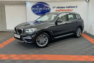 BMW X3 xDrive30d gris foncé vue 3/4 avant droit, avec phares LED allumés dans un showroom.