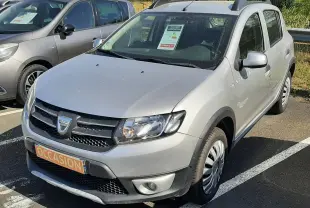 Dacia Sandero Stepway gris platine vue 3/4 avant droit, avec badge Stepway sur la porte et plaque "OCCASION".