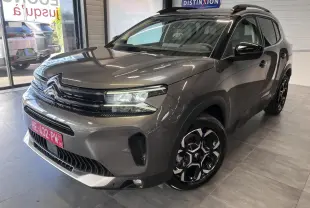 Vue 3/4 avant droit du Citroën C5 Aircross gris platinium avec jantes bi-ton et calandre noire brillante.