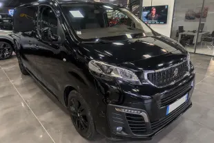 Vue 3/4 avant droit d’un Peugeot Expert Fourgon noir Perla avec calandre noire et jantes assorties en showroom.