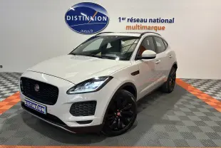 Jaguar E-PACE beige vue 3/4 avant droit avec jantes noires et toit panoramique en intérieur showroom.