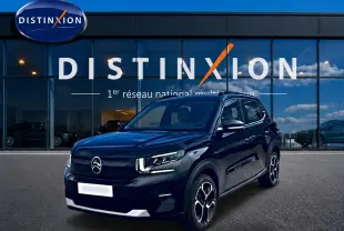 Citroën C3 113 Plus électrique noire vue 3/4 avant, avec jantes distinctives et calandre épurée devant showroom Distinxion.