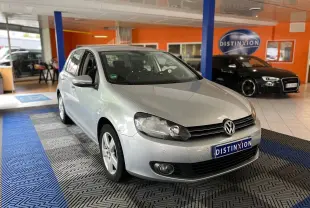 Volkswagen Golf VI gris vue 3/4 avant droit dans un showroom avec plaque Distinxion visible