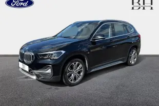 BMW X1 xDrive25eA 220ch xLine 2021 en Saphirschwarz vue 3/4 avant droit avec jantes alu et calandre chromée.