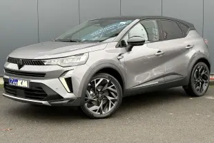 Renault Captur 2025 gris Cassiopée avec toit noir, vue 3/4 avant côté gauche, jantes aluminium 19 pouces Elixir.