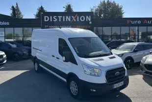 Ford Transit Fourgon blanc vu en 3/4 avant droit sur un parking devant un bâtiment commercial.
