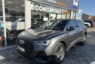 Audi Q3 Sportback gris Daytona en 3/4 avant droit avec calandre noire et jantes 20 branches contrastées.