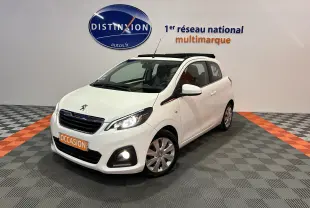 Peugeot 108 blanc vue 3/4 avant droit avec toit ouvrant et phares allumés en intérieur showroom.
