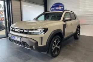 Vue 3/4 avant d'un Dacia Duster beige Sandstone 2025 avec jantes alliage 18 pouces et barres de toit noires.