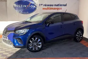 Renault Captur bleu 2024 en vue 3/4 avant droit, avec jantes alliage et phares LED visibles en intérieur showroom.