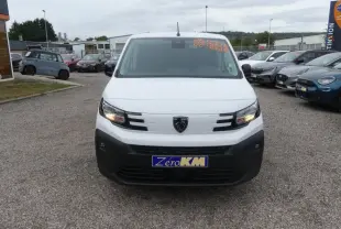 Vue avant d'un Peugeot Partner XL blanc avec calandre noire et phares allumés sur un parking.