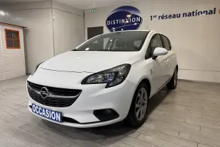 Opel Corsa blanc vue 3/4 avant droit en intérieur, avec plaque "OCCASION" et jantes alliage visibles.