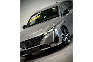 Vue 3/4 avant droit de la Peugeot 308 gris sélénium avec calandre noire brillante et jantes alliage 18 pouces.