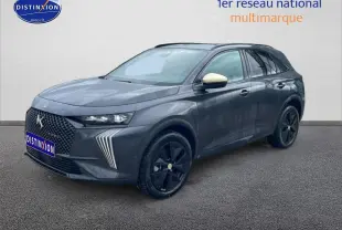 DS7 gris titane en 3/4 avant droit, avec calandre distinctive et jantes noires brillantes.