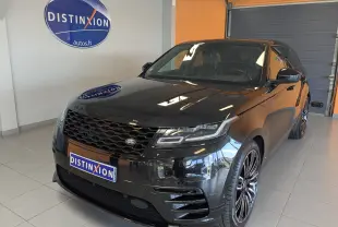 Vue 3/4 avant d'un Range Rover Velar noir brillant avec calandre hexagonale et jantes alliage noires en concession.