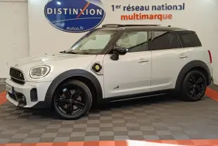 Vue de profil droit d'une MINI Countryman Cooper SE hybride rechargeable blanche avec toit noir et jantes noires.