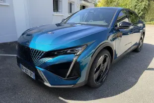 Peugeot 408 PHEV 225 GT bleu vue 3/4 avant droit avec calandre noire et jantes noires distinctives.