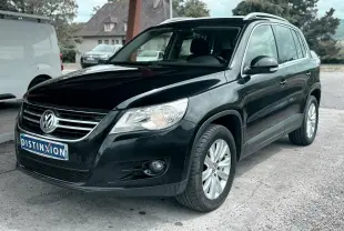 Volkswagen Tiguan noir vu en 3/4 avant droit avec jantes alliage et calandre chromée.
