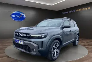 Vue 3/4 avant droite du Dacia Duster Full Hybrid 140 Journey gris schiste avec jantes spécifiques et calandre marquée.