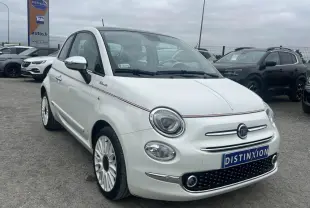 Fiat 500 blanche vue 3/4 avant droit avec bande rouge décorative et jantes multibranches sur parking.