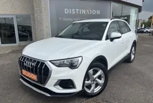 Audi Q3 blanc Glacier métallisé vue 3/4 avant droit, calandre chromée et jantes alu 5 branches visibles.