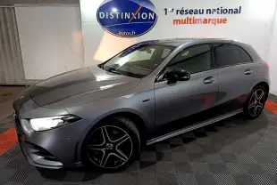 Vue 3/4 avant droit d'une Mercedes Classe A 250 e AMG Line gris foncé avec jantes alliage noires et phares LED allumés.