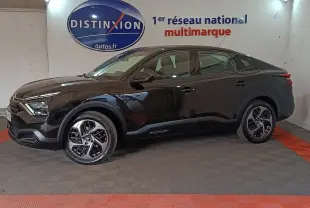 Vue de profil côté gauche d'une Citroën C4 X noire 2023 avec jantes distinctives et lignes fluides.