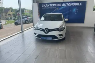 Renault Clio Blanc Glacier vue de face en intérieur, avec logo Renault bien visible sur la calandre noire.