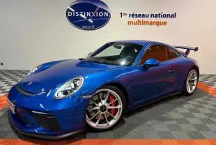 Porsche 911 GT3 bleu saphir en 3/4 avant droit, avec jantes sport et grand aileron arrière visible.
