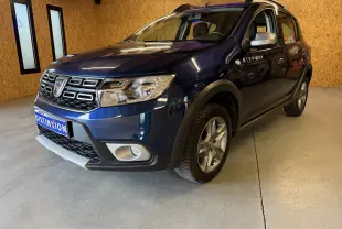 Dacia Sandero Stepway bleu vue 3/4 avant droit, avec badge Stepway sur la porte et jantes alliage.