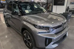 Vue 3/4 avant gauche du Citroën C3 Aircross hybride gris Mercury avec toit noir et jantes bi-ton en showroom.