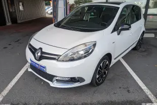 Renault Scénic IV blanc en 3/4 avant droit, avec jantes noires et chrome autour des antibrouillards.