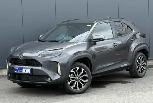 Toyota Yaris Cross gris Atlas vue 3/4 avant droit, avec jantes alliage noires et détails noirs contrastants.
