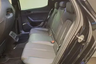 Profil droit de la CUPRA Leon 1.5 TSI 150 DS7 V 2023 en peinture métallisée Noir Minuit, avec jantes noires et grises.