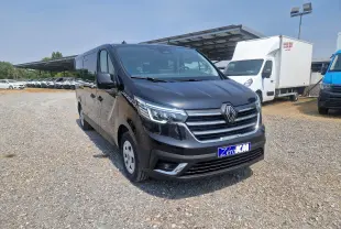 Renault Trafic Combi noir vu en 3/4 avant droit sur parking, avec calandre chromée et plaque Zero KM visible.