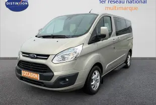 Vue 3/4 avant droit d'un Ford Tourneo Custom gris clair avec porte latérale et jantes alliage 16 pouces.