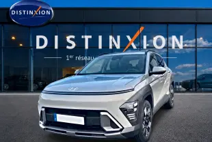Hyundai Kona gris 2025 en 3/4 avant droit, avec feux LED et jantes alliage devant showroom Distinxion.