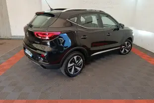 Vue 3/4 arrière droite du MG ZS Luxury 70kWh noir électrique, avec jantes distinctives et toit ouvrant visible.